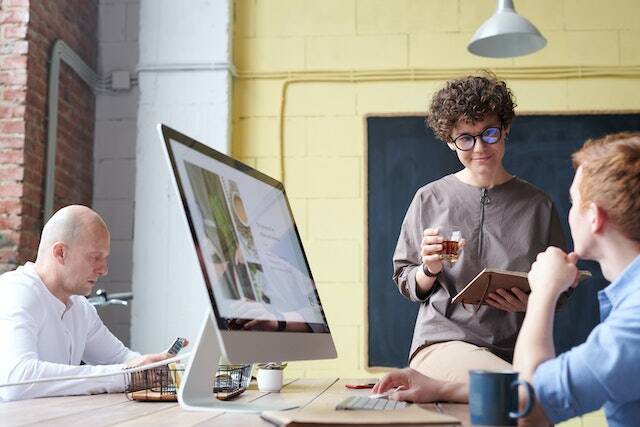 three experts looking at a computer monitor review images